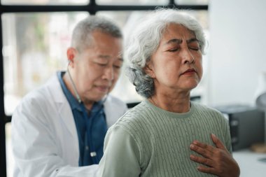 Doktor yaşlı bir hastayı muayene ediyor, yaşlı bir hastaya hastanede bir doktor tarafından teşhis konuyor, doktor, doktora tedavi planını anlatıyor..