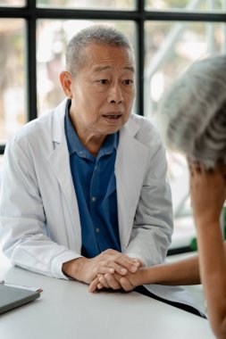 Doktor yaşlı bir hastayı muayene ediyor, yaşlı bir hastaya hastanede bir doktor tarafından teşhis konuyor, doktor, doktora tedavi planını anlatıyor..