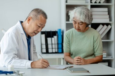 Doktor yaşlı bir hastayı muayene ediyor, yaşlı bir hastaya hastanede bir doktor tarafından teşhis konuyor, doktor, doktora tedavi planını anlatıyor..