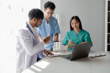 Bir grup erkek ve kadın doktor oturdu ve hastanın geçmişi hakkında konuştular, büyük bir ameliyat hakkında bir toplantı vardı, doktor hastanın belgelerini aldı ve bunları ekiple tartıştı..