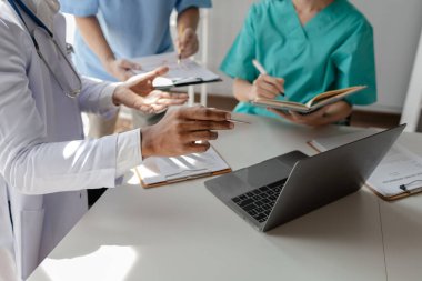 Bir grup doktor salgının sorununu çözmek için bir araya geldi, hastanede büyük bir ameliyat hakkında bir toplantı yapıldı, doktor hastanın belgelerini alıp ekiple görüştü..