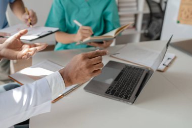 Bir grup doktor salgının sorununu çözmek için bir araya geldi, hastanede büyük bir ameliyat hakkında bir toplantı yapıldı, doktor hastanın belgelerini alıp ekiple görüştü..