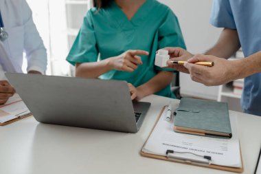 Bir grup doktor salgının sorununu çözmek için bir araya geldi, hastanede büyük bir ameliyat hakkında bir toplantı yapıldı, doktor hastanın belgelerini alıp ekiple görüştü..