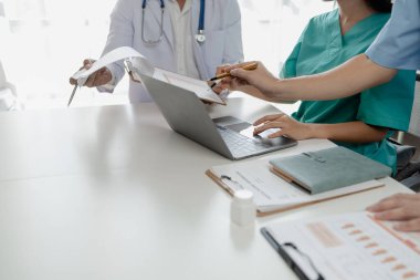 Bir grup doktor salgının sorununu çözmek için bir araya geldi, hastanede büyük bir ameliyat hakkında bir toplantı yapıldı, doktor hastanın belgelerini alıp ekiple görüştü..