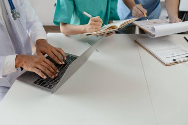 Bir grup doktor salgının sorununu çözmek için bir araya geldi, hastanede büyük bir ameliyat hakkında bir toplantı yapıldı, doktor hastanın belgelerini alıp ekiple görüştü..