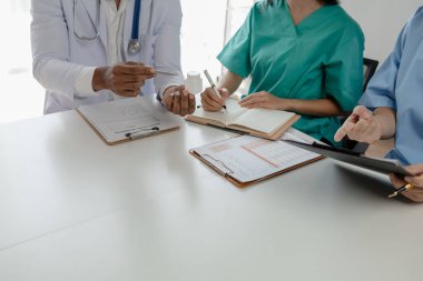 Bir grup doktor salgının sorununu çözmek için bir araya geldi, hastanede büyük bir ameliyat hakkında bir toplantı yapıldı, doktor hastanın belgelerini alıp ekiple görüştü..