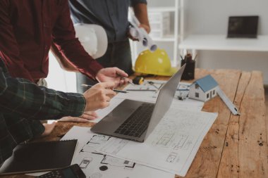 Mimarlar ve mühendisler ev yapımı sorunlarına çözüm bulmak için birlikte çalışırlar, mülk bir grup mühendis tarafından tasarlanmak üzeredir, mimarlar birlikte planlarını gözden geçiriyorlar..