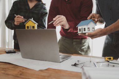 Mimarlar ve mühendisler ev yapımı sorunlarına çözüm bulmak için birlikte çalışırlar, mülk bir grup mühendis tarafından tasarlanmak üzeredir, mimarlar birlikte planlarını gözden geçiriyorlar..