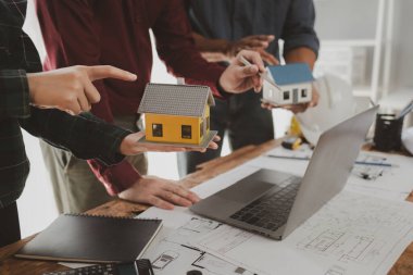 Mimarlar ve mühendisler ev yapımı sorunlarına çözüm bulmak için birlikte çalışırlar, mülk bir grup mühendis tarafından tasarlanmak üzeredir, mimarlar birlikte planlarını gözden geçiriyorlar..