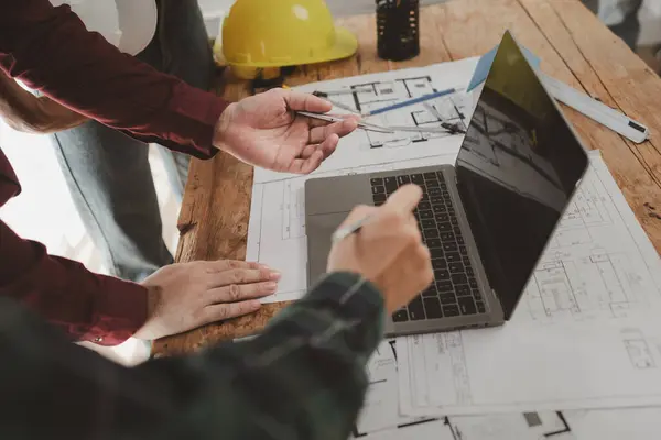 Mimarlar ve mühendisler ev yapımı sorunlarına çözüm bulmak için birlikte çalışırlar, mülk bir grup mühendis tarafından tasarlanmak üzeredir, mimarlar birlikte planlarını gözden geçiriyorlar..