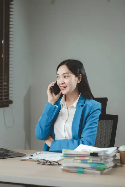 Businesswoman is talking on the phone with a partner, Businesswoman is sitting and working in the office, An entrepreneur is talking on the phone with a company customer, office idea.