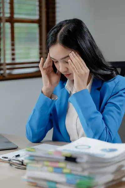 Businesswoman is stressed because of business problems in the office, worried about the company's problems, Thinking of solving the problem of stress from the loss of the company.