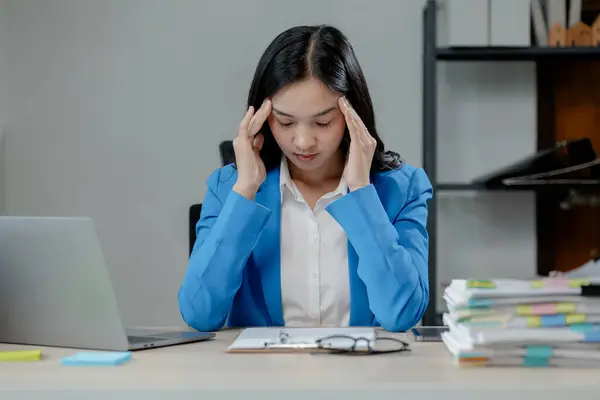 Businesswoman is stressed because of business problems in the office, worried about the company\'s problems, Thinking of solving the problem of stress from the loss of the company.