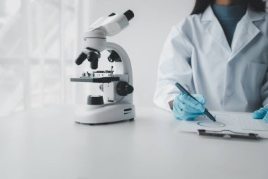 Kimyager araştırma verileri üzerine notlar alıyor, bilim adamı laboratuvarda çalışıyor, Kimyager deneysel sonuçları analiz ediyor ve laboratuvar, laboratuvar fikri üzerine notlar alıyor..