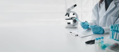 Kimyager test tüplerini kimyasal olarak analiz ediyor. Bilim adamı laboratuvarda kimyasallar üzerinde deney yapıyor. Kimyager test tüplerindeki bileşikleri kimyasal reaktörlerle ayırıyor..