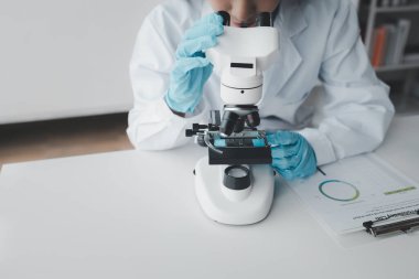Kimyager laboratuvarda bir deney yapıyor, bir bilim adamı kimyasal bileşimi analiz etmek için mikroskop kullanıyor, bilimsel bir deney laboratuvarda biyolojik cevaplar arıyor..