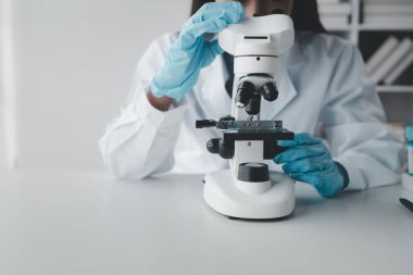 Kimyager laboratuvarda bir deney yapıyor, bir bilim adamı kimyasal bileşimi analiz etmek için mikroskop kullanıyor, bilimsel bir deney laboratuvarda biyolojik cevaplar arıyor..