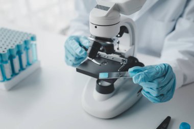 Kimyager laboratuvarda bir deney yapıyor, bir bilim adamı kimyasal bileşimi analiz etmek için mikroskop kullanıyor, bilimsel bir deney laboratuvarda biyolojik cevaplar arıyor..