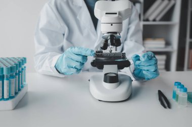 Kimyager laboratuvarda bir deney yapıyor, bir bilim adamı kimyasal bileşimi analiz etmek için mikroskop kullanıyor, bilimsel bir deney laboratuvarda biyolojik cevaplar arıyor..