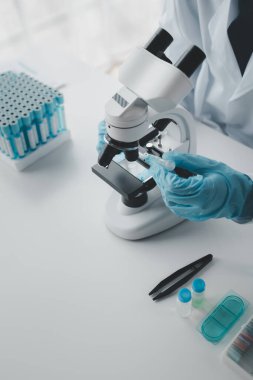 Kimyager laboratuvarda bir deney yapıyor, bir bilim adamı kimyasal bileşimi analiz etmek için mikroskop kullanıyor, bilimsel bir deney laboratuvarda biyolojik cevaplar arıyor..