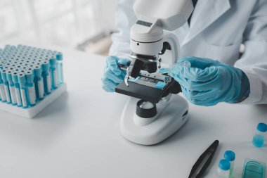 Kimyager laboratuvarda bir deney yapıyor, bir bilim adamı kimyasal bileşimi analiz etmek için mikroskop kullanıyor, bilimsel bir deney laboratuvarda biyolojik cevaplar arıyor..