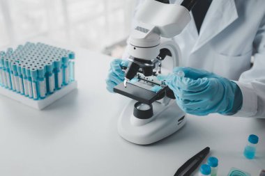 Kimyager laboratuvarda bir deney yapıyor, bir bilim adamı kimyasal bileşimi analiz etmek için mikroskop kullanıyor, bilimsel bir deney laboratuvarda biyolojik cevaplar arıyor..