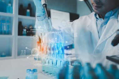 Kimyager test tüplerini kimyasal olarak analiz ediyor. Bilim adamı laboratuvarda kimyasallar üzerinde deney yapıyor. Kimyager test tüplerindeki bileşikleri kimyasal reaktörlerle ayırıyor..