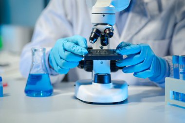 Kimyager laboratuvarda bir deney yapıyor, bir bilim adamı kimyasal bileşimi analiz etmek için mikroskop kullanıyor, bilimsel bir deney laboratuvarda biyolojik cevaplar arıyor.,