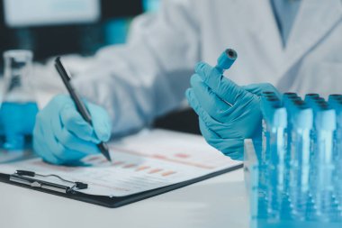 Kimyager araştırma verileri üzerine notlar alıyor, bilim adamı laboratuvarda çalışıyor, Kimyager deneysel sonuçları analiz ediyor ve laboratuvar, laboratuvar fikri üzerine notlar alıyor..