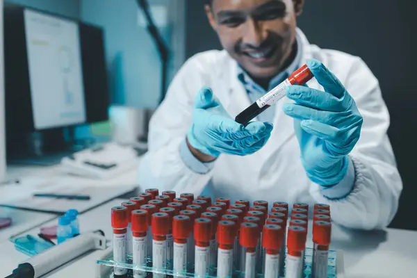 A chemist is using a microscope to search for chemicals from blood in a test tube, Chemist is chemically analyzing test tubes, Scientist is experimenting with chemicals in the laboratory,