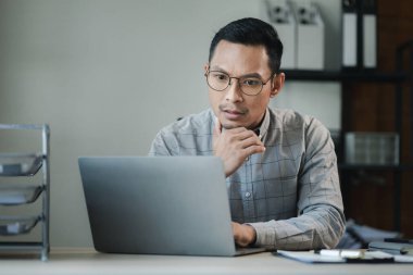 İşadamı ofisteki iş sorunları yüzünden stresli, şirketin sorunları hakkında endişeli, şirketin kaybından kaynaklanan stres sorununu çözmeyi düşünüyor,
