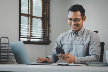 İşadamı ofiste oturuyor ve çalışıyor, Çalışan dizüstü bilgisayarda bilgi arıyor, bir girişimci şirket müşterisiyle konuşuyor,.