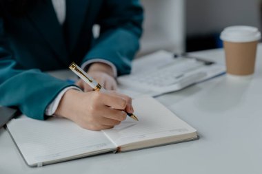 Denetçi ofiste muhasebe üzerinde çalışıyor, muhasebeci şirketin finansal likiditesini hesaplıyor, muhasebeciye vergileri hesaplaması için rakamsal veriler sunuluyor..