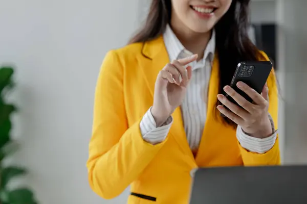 Businesswoman is working in the office and talking on the phone with a partner, Entrepreneurs use smartphones to find information in order to present it, Working in a private office at a company.