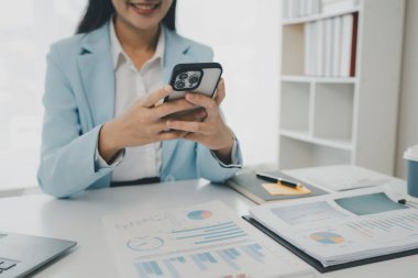 Bir girişimci, bir şirket müşterisiyle telefonda konuşuyor. İş kadını ofiste oturuyor ve çeşitli bilgileri kağıda kaydediyor.,
