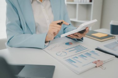 Muhasebe analisti, şirketin mali tablolarındaki bakiyeleri hesaplamak için hesap makinesine basıyor, rakamları hesaplıyor, mali tabloları ve muhasebeyi hazırlıyor, finansal muhasebe kavramlarını hesaplıyor.