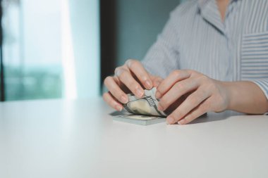 Bir işletme sahibi, bir finans kitabına para sayıyor ve notlar tutuyor, finansör, müşterinin yatırımından elde edilen geliri teyit ediyor, muhasebeci, toplam ne kadar para olduğunu hesaplıyor..