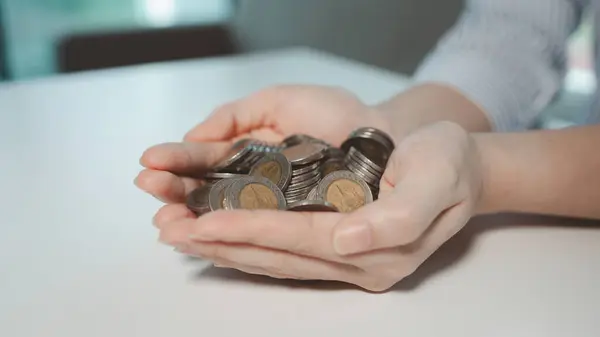 The accountant held out a handful of coins, A financier collects some coins from customers, Employees offer customers efficient ways to save money.