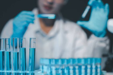 Coronavirus aşısı geliştirmek için mikroskopla çalışan biyokimyasal araştırmacı Gözlüklü Güzel Kadın Bilimadamının Portresi Test Analizi için Mikropipet Kullanıyor.