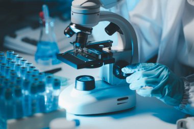 Coronavirus aşısı geliştirmek için mikroskopla çalışan biyokimyasal araştırmacı Gözlüklü Güzel Kadın Bilimadamının Portresi Test Analizi için Mikropipet Kullanıyor.
