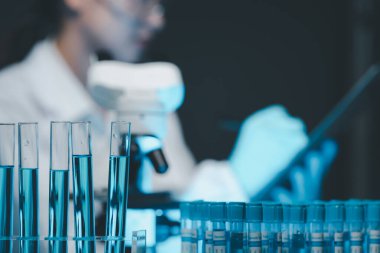 Coronavirus aşısı geliştirmek için mikroskopla çalışan biyokimyasal araştırmacı Gözlüklü Güzel Kadın Bilimadamının Portresi Test Analizi için Mikropipet Kullanıyor.