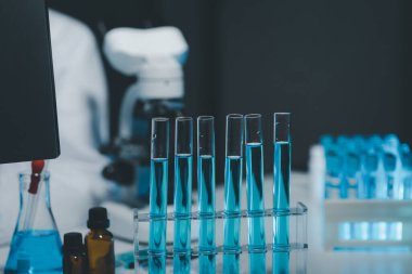 Coronavirus aşısı geliştirmek için mikroskopla çalışan biyokimyasal araştırmacı Gözlüklü Güzel Kadın Bilimadamının Portresi Test Analizi için Mikropipet Kullanıyor.