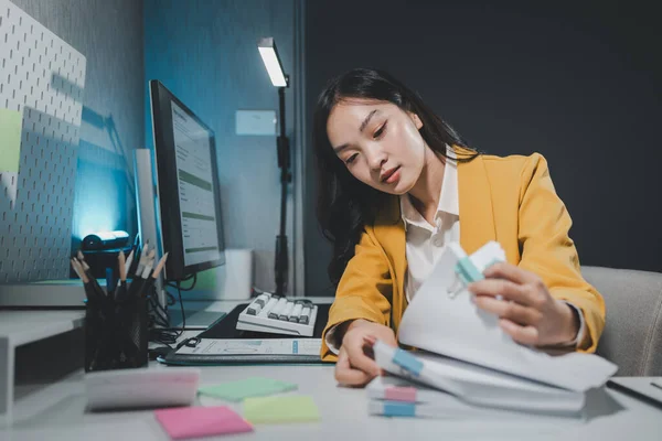 Desperate office worker overwhelmed with paperwork, stressed, Young businesswoman, office worker people working with stack of papers, her desk is covered with paperwork.