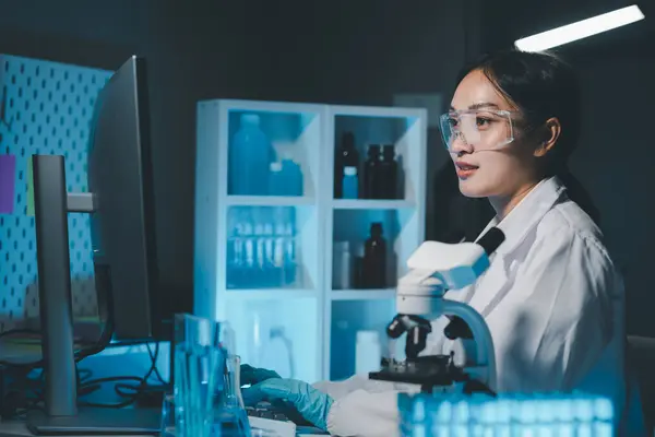 biochemical research scientist working with microscope for coronavirus vaccine development in, Portrait of a Beautiful Female Scientist in Goggles Using Micropipette for Test Analysis.