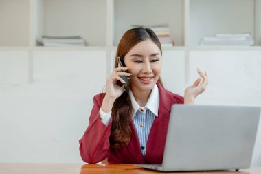 Girişimci telefonda şirket müşterisiyle konuşuyor, ofiste güzel bir kadın, mutlu, iş kadını internet telefonunu kapatıyor, iş kadını akıllı telefondan e-postaları kontrol ediyor., 