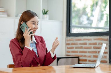 Girişimci telefonda şirket müşterisiyle konuşuyor, ofiste güzel bir kadın, mutlu, iş kadını internet telefonunu kapatıyor, iş kadını akıllı telefondan e-postaları kontrol ediyor., 