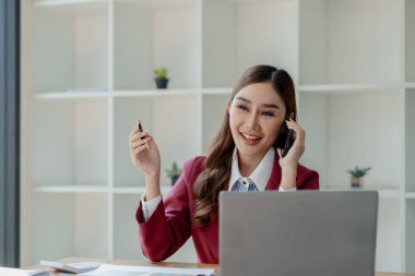 Girişimci telefonda şirket müşterisiyle konuşuyor, ofiste güzel bir kadın, mutlu, iş kadını internet telefonunu kapatıyor, iş kadını akıllı telefondan e-postaları kontrol ediyor., 