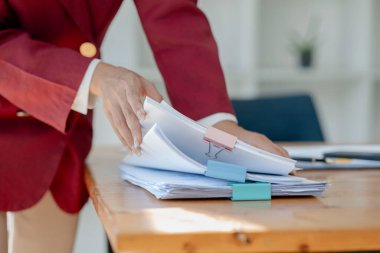 İş kadını elleri kağıt yığınları içinde arama için çalışır, iş kadını kağıt yığınları içinde çalışır tamamlanmamış dosyaları kontrol etmek için çalışır işte meşgul olur..