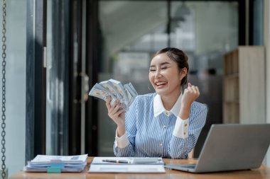 Bir işletme sahibi, bir finans kitabına para sayıyor ve notlar alıyor, finansör, müşterinin yatırımından elde edilen geliri teyit ediyor., 