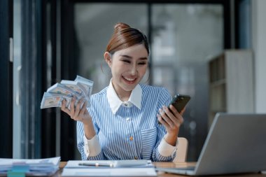 Bir işletme sahibi, bir finans kitabına para sayıyor ve notlar alıyor, finansör, müşterinin yatırımından elde edilen geliri teyit ediyor., 